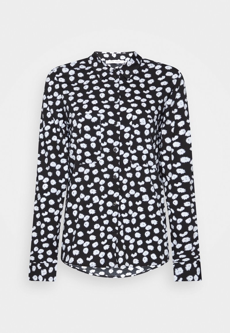 Camisa negra de manga larga con un patrón floral blanco, que presenta un cuello tipo punta, frente abotonado y dobladillo redondeado. Textura de tela suave.
