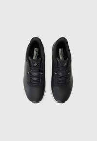 Pantofi sport negri cu un superior sintetic neted, textură din plasă, design cu șireturi și talpă albă, având un branding subtil pe limbă.
