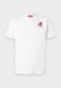 Hvit bomull t-skjorte med korte ermer. Har et lite brodert edderkoppdesign på venstre bryst og et rødt logomerke.