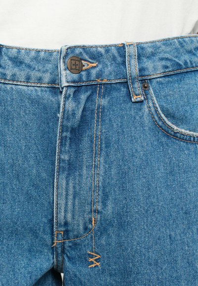 Blue denim jeans with a straight cut, featuring a metal button closure, orange stitching, and a distressed texture around the zipper area.