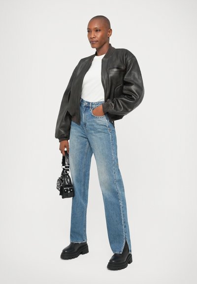 Must have must must must have black leather bomber jacket, white t-särk, ja sinised sirged teksad külgvahesegude ja jämedad mustad platvormisaapad.
