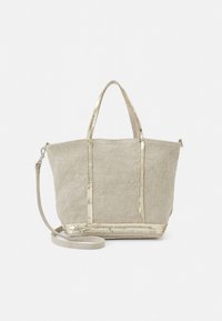 Canvas tote bag in beige with metallic gold accents, rectangular shape, dual handles, and detachable strap. Features a textured finish.
