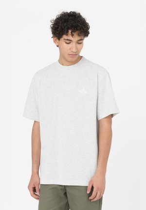 Camiseta de algodón gris claro con mangas cortas y cuello redondo. Presenta un pequeño logo blanco en el pecho. Textura suave.