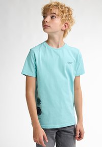 Camiseta de algodón de color azul claro con mangas cortas, que presenta acentos gráficos en negro y texto en la parte frontal y lateral. Diseño recto.