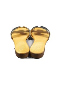 Sandal nera con una finitura liscia e opaca, punta aperta e una leggera suola in sughero. L'interno presenta una fodera in pelle beige per il comfort.
