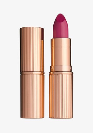 Lippenstift mit einer leuchtend pinken Mine, untergebracht in einer polierten roségoldenen Hülse mit vertikalen Rillen. Kappe abgenommen, um das Produkt zu zeigen.