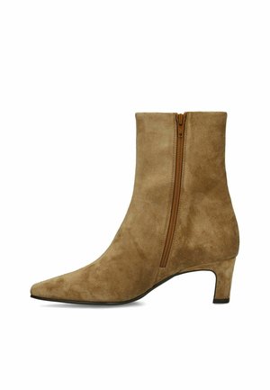 Enkellaars van lichtbruin suède met een ritssluiting aan de zijkant, een puntige neus en een lage, gebogen hak.