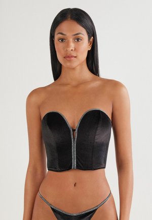 Czarny aksamitny strapless bustier z dekoltem w kształcie serca i zdobieniem na suwaku z rhinestonami z przodu. Gładka tekstura i strukturalna sylwetka.