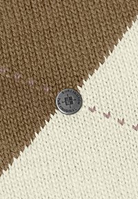 Tissu tricoté présentant un motif diagonal marron et crème, avec des accents de surpiqûres violettes et un bouton rond en métal Burlington.