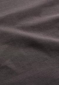 Tela gris oscuro con una textura suave, que presenta un ribeteado fino y uniforme y arrugas sutiles, lo que indica un material suave y elástico.