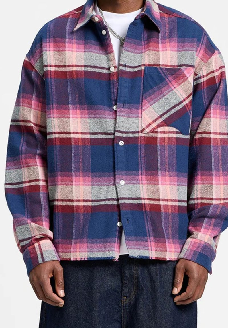 Camicia in flanella a quadri blu, rosa e grigia. Maniche lunghe, chiusura con bottoni, una tasca sul petto, tessuto morbido e vestibilità rilassata.