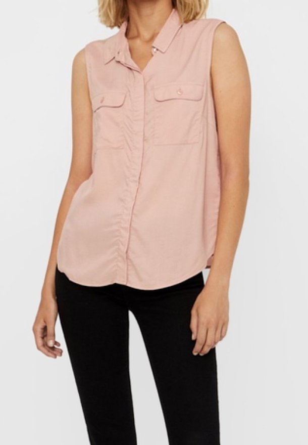 Blouse sans manches rose clair avec une fermeture boutonnée sur le devant, deux poches poitrine et une texture de tissu douce et lisse. Coupe décontractée avec ourlet arrondi.