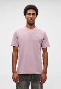 Ανοιχ�τό ροζ βαμβακερό t-shirt με κοντά μανίκια και στρογγυλή λαιμόκοψη. Διαθέτει ένα μικρό μαύρο λογότυπο στην αριστερή περιοχή του στήθους. Μοναδική απαλότητα.