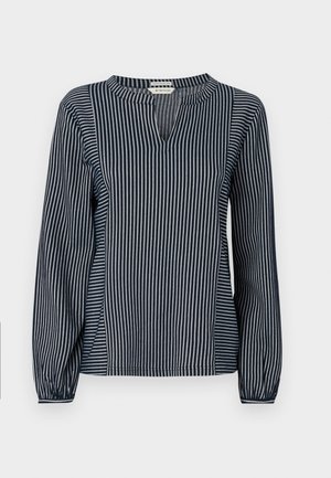 Blouse à manches longues rayée verticalement bleu marine et blanche avec un col rond, dotée d'une petite fente à l'avant et de poignets froncés. Tissu doux.