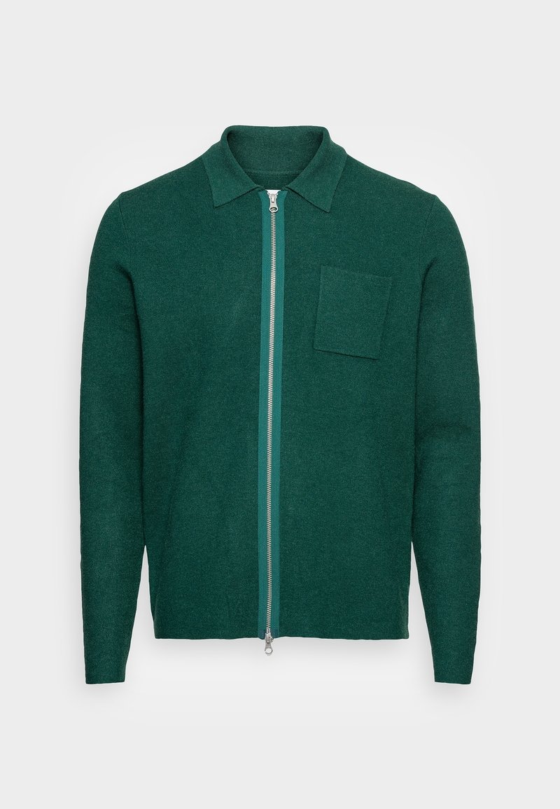 Pull vert foncé à manches longues avec fermeture éclair, col et une poche poitrine, présenté sur un fond blanc.