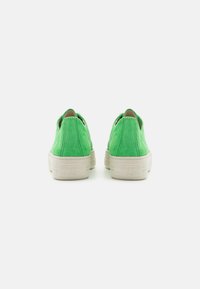 Green suede slip-on shoes with a simple design, featuring a white textured rubber sole and subtle logo detail on the heel.