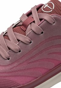 Purple athletic shoe featuring mesh upper, textured fabric, and flat laces. Notable wave patterns and logo accent on the side.