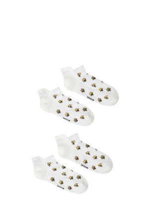 To par hvide ankelstrømper med gule og sorte bi-mønstre spredt over stoffet.