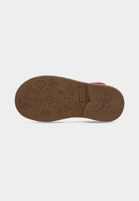 Καφέ λαστιχένια σόλα με μοτίβα από λουλούδια και πεταλούδες, με στρογγυλεμένο σχήμα και υφή για καλύτερη πρόσφυση.