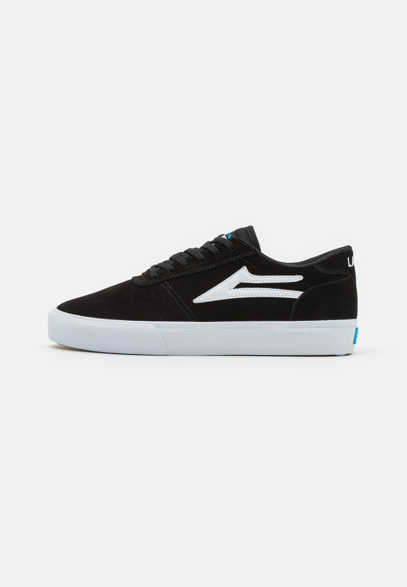 Pantofi de skate din suede negru cu logo și accente albe, având o talpă din cauciuc alb. Design cu șireturi și guler căptușit pentru confort.