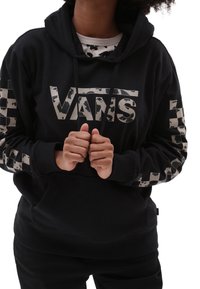 Felpa nera con cappuccio e un grande logo Vans sul davanti. Presenta un motivo testurizzato e dettagli a scacchi sulle maniche. Cappuccio regolabile con cordini.