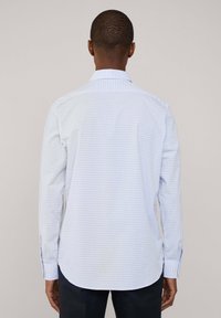 Lange mouwen geruite shirt in lichtblauw en wit. Heeft een klassieke kraag en een afgeronde zoom. De stof lijkt glad en lichtgewicht.