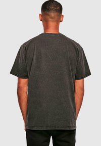 Dark gray cotton t-shirt with short sleeves, visible stitching, and a classic crew neck design. The fabric has a slightly textured appearance.