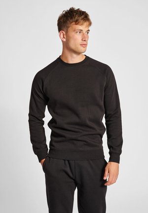 Zwarte katoenen sweatshirt met een ronde hals, ribgebreide manchetten en zoom. Kenmerkt zich door een eenvoudig ontwerp en een ontspannen pasvorm. Geen patronen of graphics.