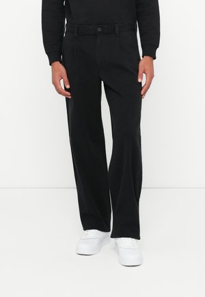 Black, wide-leg trousers with a button closure and belt loops. Made from a smooth fabric, featuring side pockets and a clean design.