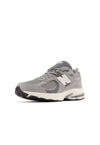Gray athletic shoe made of mesh and suede, featuring a white logo, round laces, and a textured rubber sole. Accented with cushioned heel.