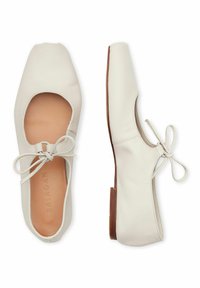 Scarpe flat in pelle bianca con punta quadrata, caratterizzate da un design con ritagli e un accento a fiocco. Soletta e suola in pelle marrone chiaro.