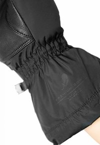 Schwarzer Daunenjackenärmel mit strukturiertem Lederakzent, elastischem Bündchen und einem Etikett mit der Aufschrift „Premium Daune Natürliche Wärme“. 