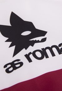 Witte stof met een bordeauxrode streep. Bevat een zwart wolf-logo en "as roma" in vetgedrukte zwarte tekst, met een soepel, atletisch design.