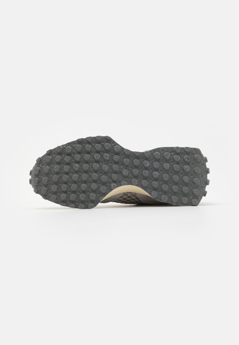 Suela de zapato con un patrón de tread circular negro sobre un fondo blanco, vista desde la parte inferior.