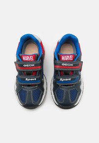 Svart och marinblå sneakers med röda och blå detaljer, meshmaterial, dubbla Velcro-remmar och 'MARVEL GEox Sport'-branding på remmarna.