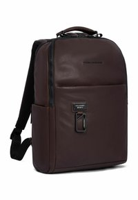 Brauner Leder-Rucksack mit einem schlanken Design, Reißverschluss, Vorderfach und metallischem Akzent. Verfügt über gepolsterte Schultergurte.