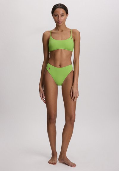 Σετ πράσινου μπικίνι με εφαρμοστό τριγωνισμό σουτιέν και ψηλόμεσο κάτω μέρος. Λείο ύφασμα, με μικρό λογότυπο ως λεπτομέρεια στο πλάι.