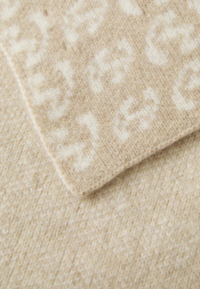 Beige uldne stof med et struktureret mønster. Et stykke har et diskret lysere logo-design, mens det andet viser en mere ensartet tekstur.