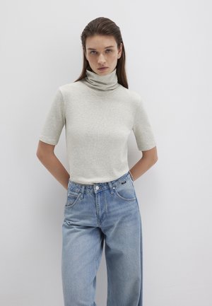 Hellgraues, geripptes Rollkragenoberteil mit kurzen Ärmeln, kombiniert mit hochgeschnittenen hellblauen Jeans. Sanfte Textur und figurbetontes Design.