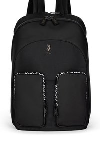 Musta reppu, jossa on kaksi etutaskua, vetoketjuilla ja logo. Materiaali vaikuttaa kestävältä, sillä on sileä pinta ja säädettävät olkahihnat.