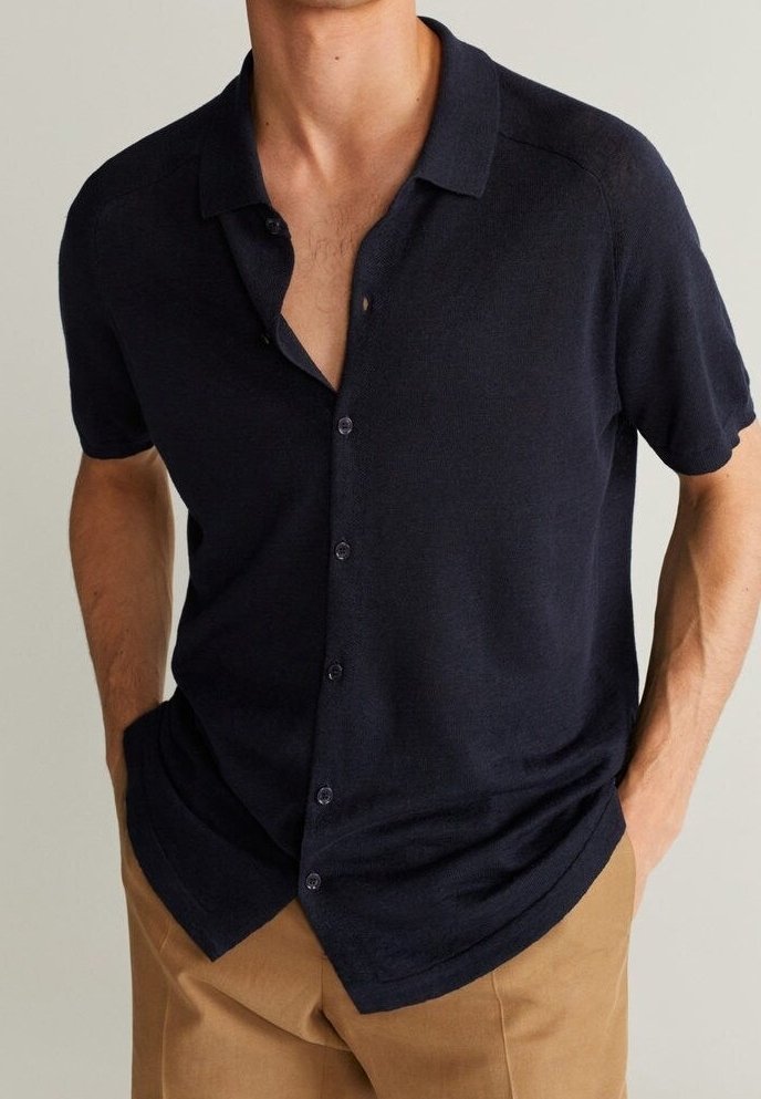 Camicia blu navy a maniche corte con bottoni, realizzata in tessuto testurizzato, dotata di collo e orlo leggermente curvo.