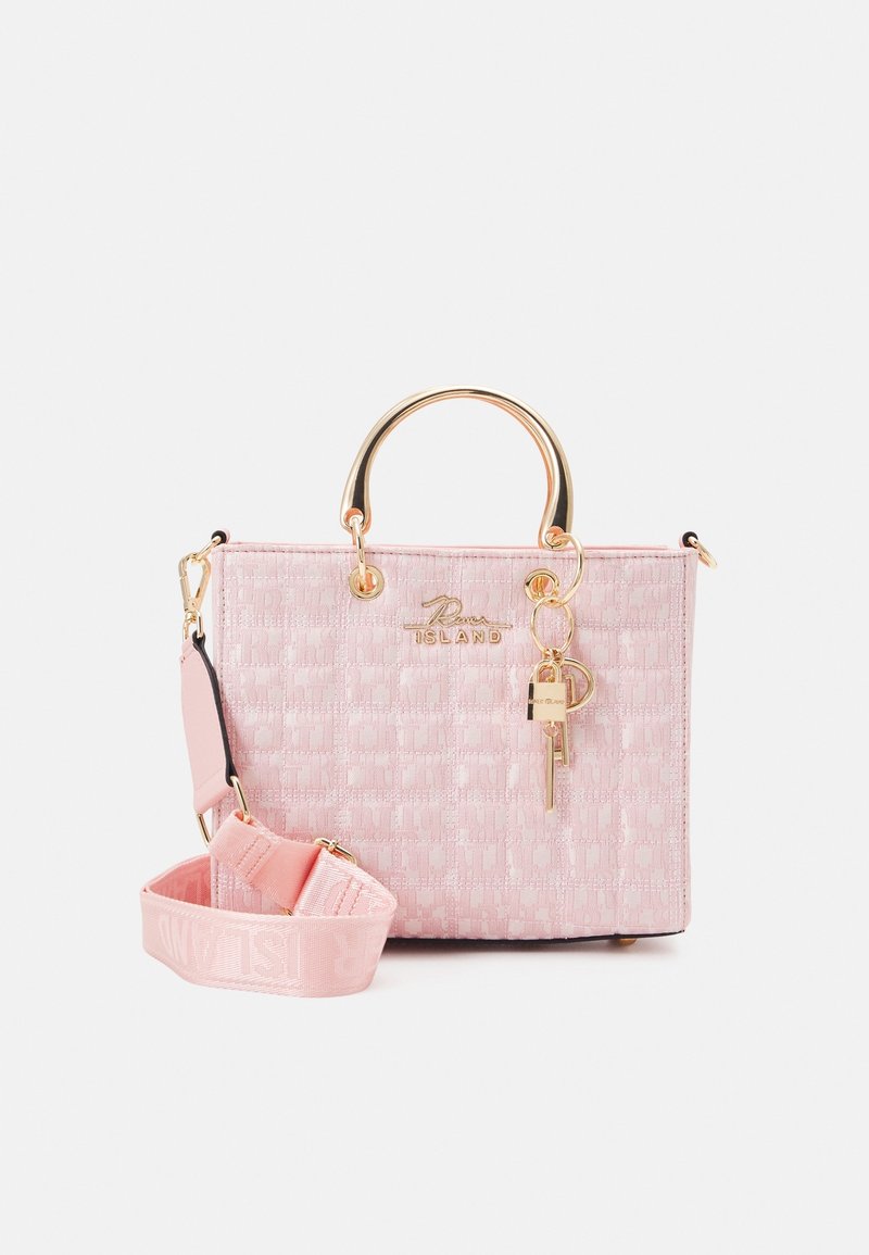 Sac à main rose texturé avec poignées en métal doré, une bandoulière rose amovible, et un porte-clés doré en forme de clé et de serrure suspendu à l'avant.