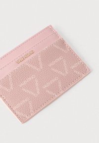 Καρτοθήκη Valentino σε ανοιχτό ροζ δέρμα, με υφή και ανάγλυφο λογότυπο, και μια λεια αντίθετη επάνω επιφάνεια.