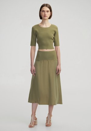 Olive green ribbed knit crop top with short sleeves paired with a matching A-line midi skirt, featuring smooth fabric and a fitted waist.