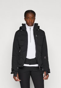 Melna pūkaina jaka ar kapuci, ar rāvējslēdzēja priekšējo daļu un elastīgām aprocēm. Ir gluda tekstūra un rozā akcenti uz rāvējslēdzējiem.