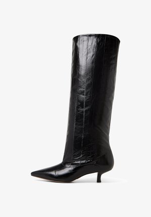Schwarze knielange Stiefel aus glänzendem Material mit Krokodilstruktur, spitzer Zehenform und niedrigem Kittenheel. Vertikale Nahtdetails sind sichtbar.
