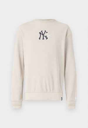 Beige ribbet sweatshirt med et navy logo på brystet, rund hals og ribbede manchetter. Glat tekstur med et afslappet fit design.