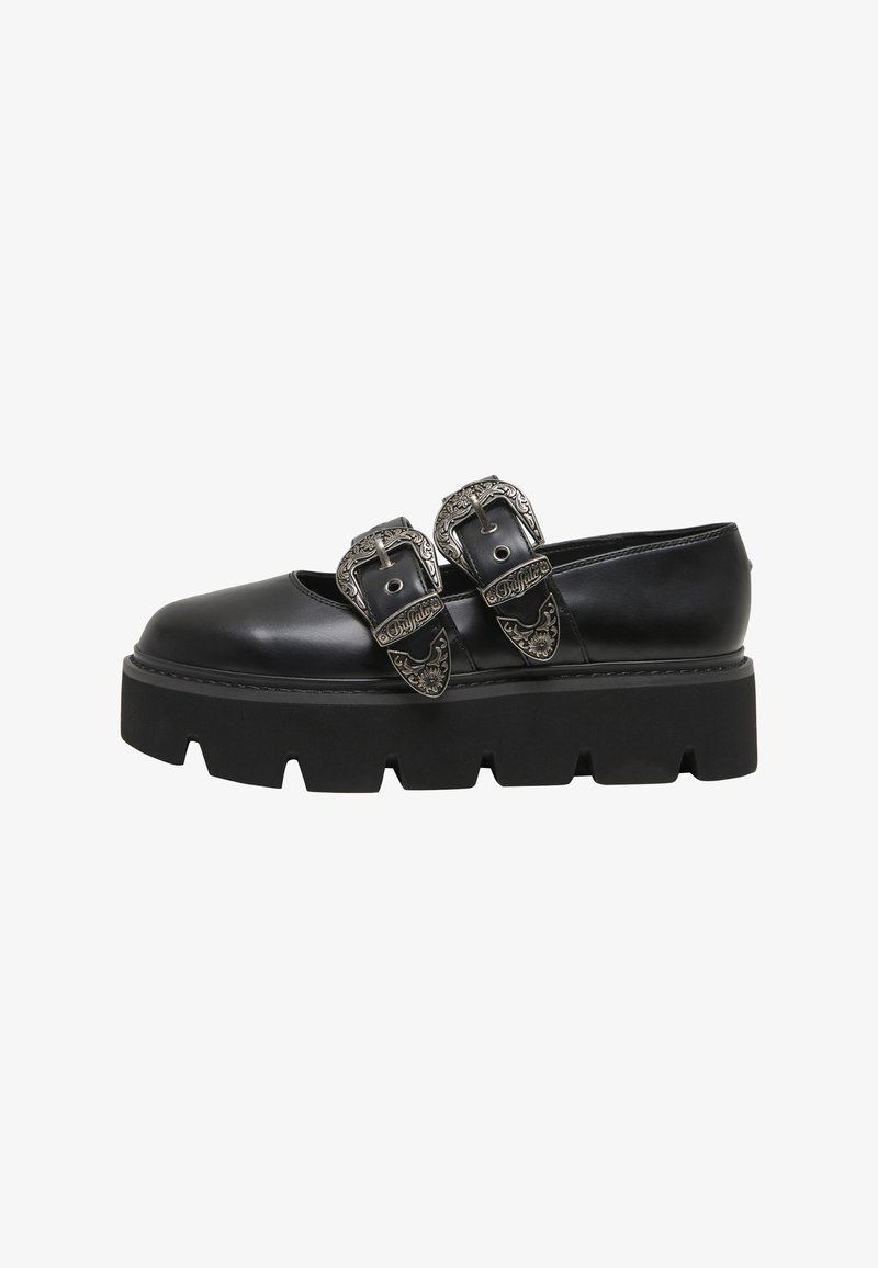 Chaussure plateforme en cuir noir avec une semelle épaisse à crampons et deux grandes boucles argentées ornées sur le coup de pied.