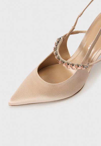 Beżowy satynowy but na wysokim obcasie z zaostrzonym noskiem i tylnym paskiem, ozdobiony dekoracyjnym paskiem z różowymi i przejrzystymi kamieniami.