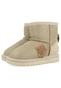 Bottines en suede beige avec une finition pailletée, ornées d'un accent en forme d'étoile duveteux, d'un bout rond et d'une semelle en caoutchouc texturée.